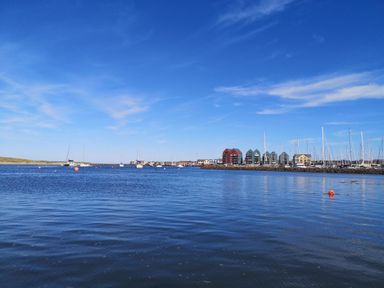 A harbor with sailboats and buildings near the water at Victoria Cottage in Amble