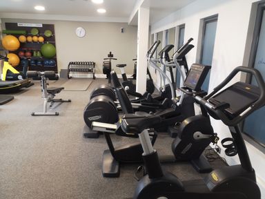 Indoor gym with exercise bikes treadmills dumbbells and fitness balls at Victoria Cottage in Amble