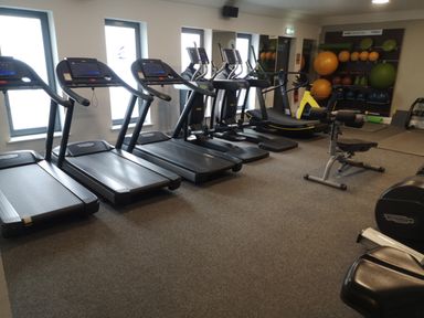 A gym room with treadmills exercise balls and fitness equipment at Victoria Cottage in Amble