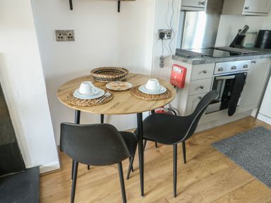A kitchen with a table and chairs setup at Bwthyn Moelfre