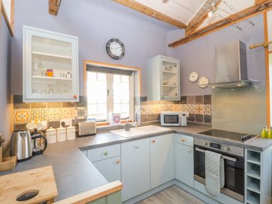 A kitchen with cabinets countertops a sink an oven and a microwave at Little Willow Farrington near Child Okeford