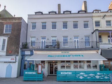 A building with a rockfish restaurant on the ground floor and residential windows above at 6 The Beaches in Weymouth