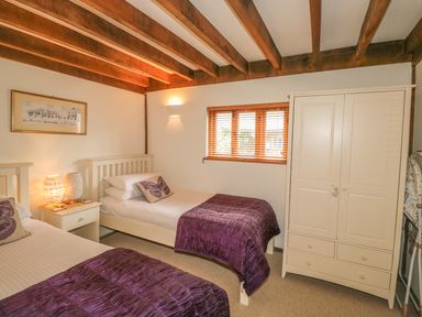 A bedroom with two single beds a white wardrobe and a nightstand with lamps at Trevinny Lodge No 37 Davidstow near Boscastle