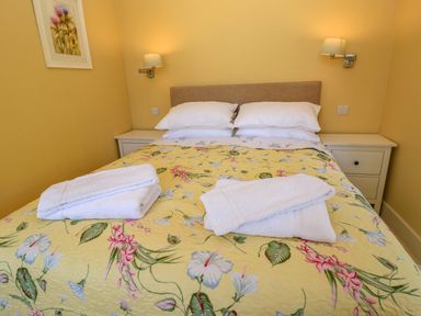 A bedroom with a bed and towels at Pheasant Cottage in Priston Village, BATH