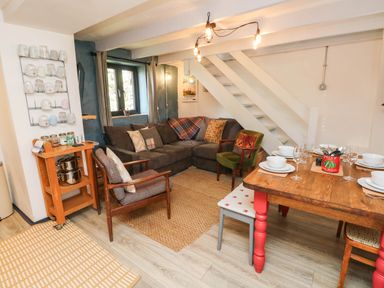 A living room with a sofa and dining table at Farmhand Cottage near Narberth