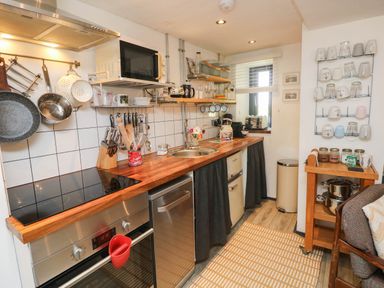 A kitchen with appliances and utensils at Farmhand Cottage near Narberth
