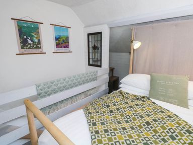 A bedroom with a bed and wall art at Farmhand Cottage near Narberth