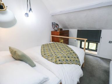 A bedroom with a bed and chest of drawers at Farmhand Cottage near Narberth
