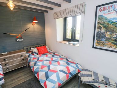 A bedroom with two beds and a window at Farmhand Cottage near Narberth