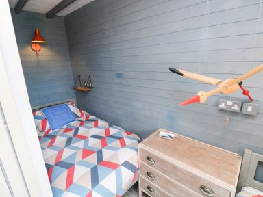 A bedroom with a bed and shelf at Farmhand Cottage near Narberth