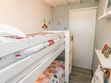 A bedroom with a bunk bed and wall shelf at Farmhand Cottage near Narberth