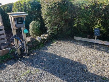 An electric vehicle charging station with a sign at Farmhand Cottage near Narberth