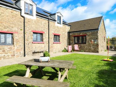 An outdoor area with a table and chairs at Farmhand Cottage near Narberth