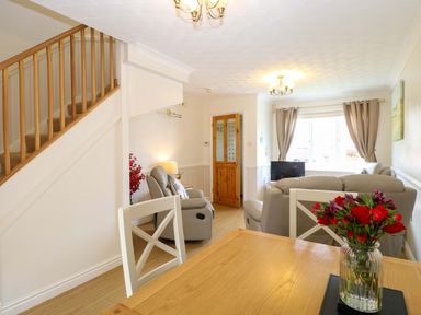 A living room with a sofa and a table at Breydon Cottage in Bradwell near Gorleston-On-Sea