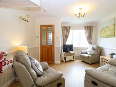 A living room with two recliner chairs and a television at Breydon Cottage in Bradwell near Gorleston-On-Sea