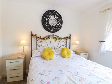 A bedroom with a bed and bedside lamps at Breydon Cottage in Bradwell near Gorleston-On-Sea
