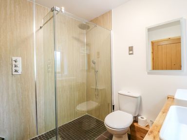 A bathroom with a glass enclosed shower toilet and sink at Dorado Lodge in Thorpe-on-the-Hill