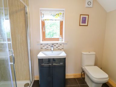 A bathroom with a shower enclosure sink cabinet and toilet at Dorado Lodge in Thorpe-on-the-Hill
