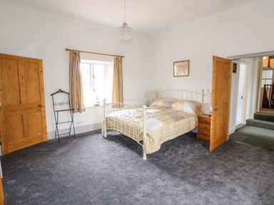 A bedroom with a double bed bedside table and two wooden doors at Southrepps Lodge in Southrepps