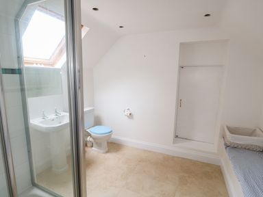 A bathroom with a shower cubicle sink toilet and a wicker basket at Southrepps Lodge in Southrepps