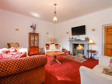 A living room with sofas a coffee table fireplace and a cabinet at Southrepps Lodge in Southrepps