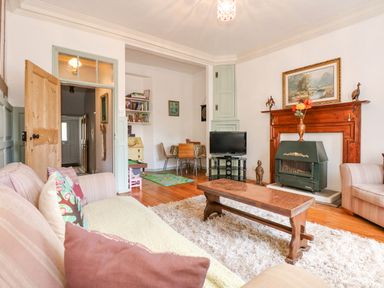 A living room with sofas pillows coffee table fireplace and television at Southrepps Lodge in Southrepps