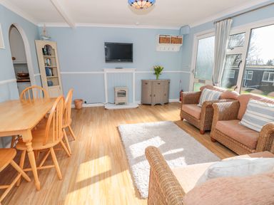 A living room with wicker sofas and wooden dining table at The Borrowers in Dartmouth