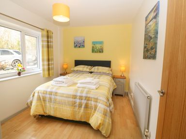 A bedroom with a double bed and bedside tables with lamps at Plas Marchog Annexe in Rhoscefnhir near Pentraeth