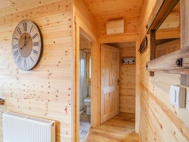 A wooden hallway with doors leading to a bathroom and another room at Alken Cabin in Bushmills County Antrim