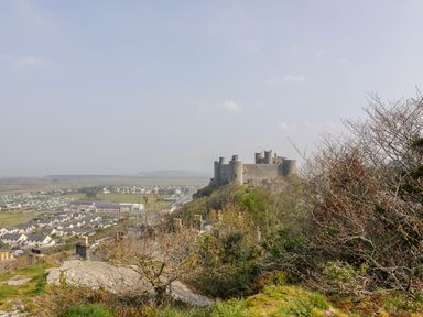 A castle on a hill overlooking a town and open land at Llety Perygl in Harlech
