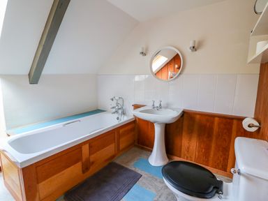 A bathroom with a bathtub pedestal sink and toilet at Plasybangor in Newport Pembrokeshire