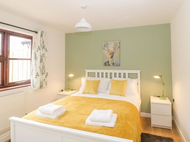A bedroom with a double bed and yellow bedding at The Forge in Shipham