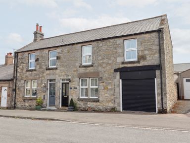 A house with windows and a garage at Hasting Dairy in North Sunderland near Seahouses