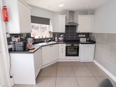 A kitchen with an oven, sink, and dishwasher at Hasting Dairy in North Sunderland near Seahouses