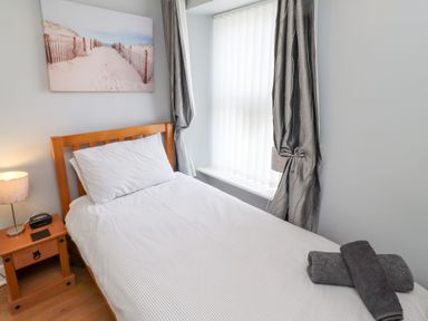 A bedroom with a single bed and window at Hasting Dairy in North Sunderland near Seahouses