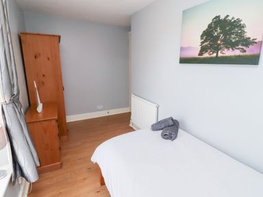 A bedroom with a bed and wardrobe at Hasting Dairy North Sunderland near Seahouses
