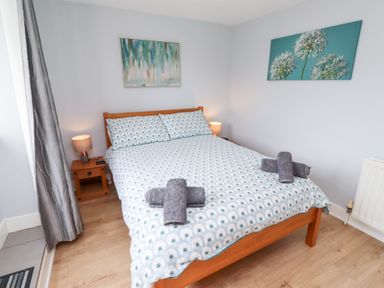 A bedroom with a double bed and bedside table at Hasting Dairy North Sunderland near Seahouses