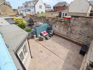 A garden with seating area and plants at Hasting Dairy in North Sunderland near Seahouses