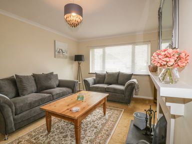 A living room with two gray sofas a wooden coffee table and a lamp at Dune Haven in Goonhavern near Perranporth