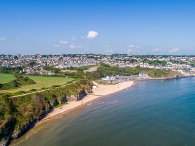 A beach with cliffs and houses at Cysgod Y Capel in Benllech
