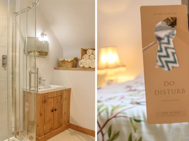 A bathroom with a glass shower and wooden cabinet next to a bed with a do not disturb sign at The Old Laundry in North Tawton