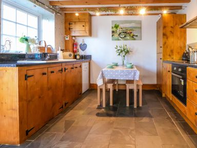 A kitchen with a table and chairs at Woodland Cottage in Garth