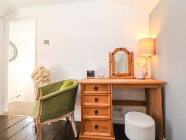 A desk with a chair and lamp at Woodland Cottage in Garth