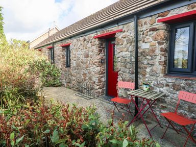 An outdoor area with stone wall, furniture and plants at Grain Store near Narberth