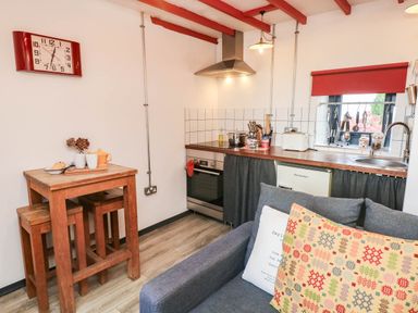 A kitchen with a table and stools at Grain Store near Narberth