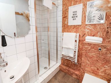 A bathroom with a shower, sink, and towel rack at Grain Store near Narberth