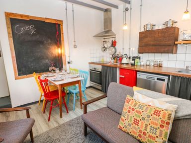 A kitchen with colorful chairs and wooden countertop at Cattle Shed near Narberth