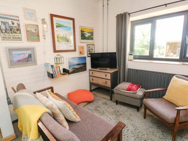 A living room with a sofa and armchair at Cattle Shed near Narberth