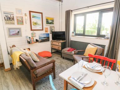 A living room with a sofa and dining table at Cattle Shed near Narberth