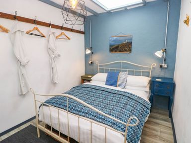 A bedroom featuring a bed, nightstand, and wall art at Cattle Shed near Narberth